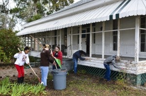 MHS students (left to right) Mariah Morton, Kelsey Gomes, Marissa Stough, Tyler Robinson and Gus Walker work on the front yard and porch of the house.