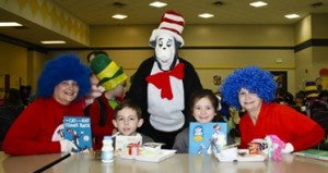 Patti Littleton (Thing Two), Linda Blankenship (Cat in the Hat) and Jeannie McGee (Thing One) visit with Samuel Sims and Hailee Pitts in the JES lunchroom.