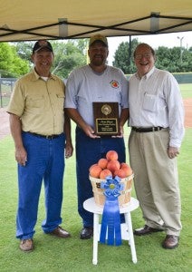 Mark Knight (center) of M&M Farms holds his plaque for winning first place for his peaches at the Chilton County Peach Auction. Also pictured are Chilton County Farmers Federation President Wendell Kelley (left) and John McMillan, Commissioner of the Alabama Department of Agriculture.