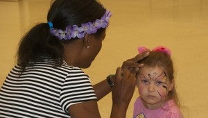 Kaylee Taylor gets her face painted by Hope Swindle during a special ceremony held on Friday for the summer reading program held at the Jemison Public Library.