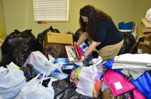 Mitchell sorts through bags full of donated items, including clothes and shoes, to be given away through Christ's Closet.
