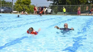 Cole Simmons (left), 7, swims a lap across the pool.