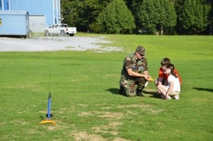 Maj. Sam Ogilvie shows Landon Headley, 9, and Hannah Holt, 9, how to operate the device for launching a rocket at the end of the Civil Air Patrol cadets' presentation. 