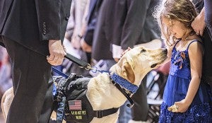 A little girl greets a service dog during the memorial service March 31.
