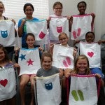 The summer sewing class participants show off their apron designs.